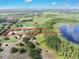 Aerial view showing property lines of land with a home, bordered by a serene lake with lush trees at 17023 Alderman Turner Rd, Wimauma, FL 33598