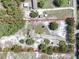 Aerial view of property with a light blue single-story home surrounded by mature trees and greenery, bordered in red at 17023 Alderman Turner Rd, Wimauma, FL 33598