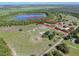 Aerial view of land with a home, surrounded by lush landscapes and a serene lake, bordered in red at 17023 Alderman Turner Rd, Wimauma, FL 33598
