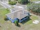 Aerial view of a light blue single-story home with a screened-in porch and mature landscaping at 17023 Alderman Turner Rd, Wimauma, FL 33598