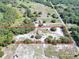 Aerial view of the property, featuring a home surrounded by mature trees, with a red boundary line at 17023 Alderman Turner Rd, Wimauma, FL 33598