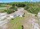 Expansive aerial view of a single-story home nestled on a generous lot surrounded by lush greenery and trees at 17023 Alderman Turner Rd, Wimauma, FL 33598