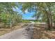 Long driveway leading to a home on a spacious lot with mature trees at 17023 Alderman Turner Rd, Wimauma, FL 33598