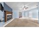 Spacious living room with cozy fireplace, neutral carpet, a ceiling fan and sliding door access at 17023 Alderman Turner Rd, Wimauma, FL 33598
