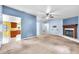 Spacious living room with fireplace, neutral carpet, access to kitchen and natural light at 17023 Alderman Turner Rd, Wimauma, FL 33598