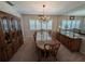 Formal dining room features a glass table, wood furniture, and a decorative chandelier at 210 Kingsway Dr, Temple Terrace, FL 33617