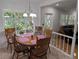 Bright dining room features hardwood table, seating for six, and large windows overlooking lush backyard at 210 Kingsway Dr, Temple Terrace, FL 33617