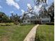 Charming two-story home with a manicured lawn, a red door and mature trees at 210 Kingsway Dr, Temple Terrace, FL 33617