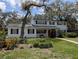 Charming two-story home with a manicured lawn, a red door and mature trees at 210 Kingsway Dr, Temple Terrace, FL 33617