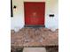 Inviting entrance featuring double red doors, brick steps and white brick at 210 Kingsway Dr, Temple Terrace, FL 33617