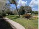 Landscaped front yard with mature trees and well-maintained lawn in a quiet neighborhood at 210 Kingsway Dr, Temple Terrace, FL 33617