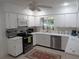 Spacious kitchen with white cabinets, stainless appliances, and plenty of countertop space at 210 Kingsway Dr, Temple Terrace, FL 33617