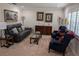 Comfortable living room features a leather sofa, stylish furnishings, and neutral carpet at 210 Kingsway Dr, Temple Terrace, FL 33617