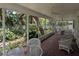 Enclosed brick porch with lots of light and ceiling fans looks out to backyard foliage at 210 Kingsway Dr, Temple Terrace, FL 33617