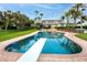 A diving board sits over the sparkling pool, with dining and lounging area overlooking the beautiful backyard at 224 Harbor View Ln, Largo, FL 33770