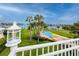 Enjoy a scenic backyard with a view of the waterfront, in ground pool, and mature palm trees at 224 Harbor View Ln, Largo, FL 33770