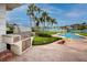 Inviting backyard featuring a pool, canal access, a built-in grill, and mature landscaping at 224 Harbor View Ln, Largo, FL 33770