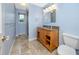 Well-lit bathroom features a wooden vanity with a granite countertop and a tiled floor at 224 Harbor View Ln, Largo, FL 33770