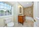 Traditional bathroom featuring a wood vanity, bathtub with shower, tile floors, and window for natural light at 224 Harbor View Ln, Largo, FL 33770