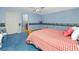 Cozy bedroom featuring blue walls, patterned wallpaper, and a red and white plaid bedspread at 224 Harbor View Ln, Largo, FL 33770
