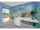 Bedroom with blue walls, an ocean-themed mural, and a door leading to a balcony at 224 Harbor View Ln, Largo, FL 33770