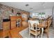 Spacious dining area features hardwood floors, brick accent wall, and flows into the kitchen at 224 Harbor View Ln, Largo, FL 33770