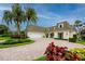 Charming two-story home featuring lush landscaping, a brick driveway, and elegant architectural details at 224 Harbor View Ln, Largo, FL 33770