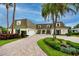 Charming home featuring a brick driveway, lush landscaping, and classic architectural details at 224 Harbor View Ln, Largo, FL 33770