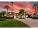 Stunning two-story home featuring lush landscaping, brick driveway, and elegant architectural details during a beautiful sunset at 224 Harbor View Ln, Largo, FL 33770