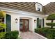 Elegant entryway featuring double doors, manicured shrubs, and charming light fixtures at 224 Harbor View Ln, Largo, FL 33770
