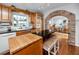 Sunlit kitchen with a butcher block island, exposed brick archway, and serene backyard views at 224 Harbor View Ln, Largo, FL 33770