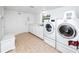 Clean laundry room with a white washer and dryer, ample cabinet space, and tile flooring at 224 Harbor View Ln, Largo, FL 33770