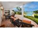 Covered patio with wicker furniture, columns, outdoor grill, and views of the pool and waterway at 224 Harbor View Ln, Largo, FL 33770