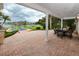 A waterfront backyard showcasing a covered patio, pool, lush greenery, and a canal view at 224 Harbor View Ln, Largo, FL 33770