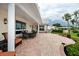 Spacious covered patio with outdoor dining, built-in grill, and manicured landscaping at 224 Harbor View Ln, Largo, FL 33770