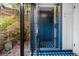 A bright blue-tiled shower with a glass door and an adjacent atrium filled with tropical plants at 224 Harbor View Ln, Largo, FL 33770