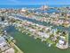 Aerial view capturing waterfront homes with boat docks along a canal leading to Tampa Bay at 241 176Th Terrace E Dr, Redington Shores, FL 33708
