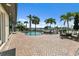 Wonderful backyard with a pool, dock, canal view and a brick patio with lounge chairs and table at 241 176Th Terrace E Dr, Redington Shores, FL 33708