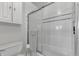Bathroom featuring a toilet and tiled tub with a sliding glass door at 241 176Th Terrace E Dr, Redington Shores, FL 33708