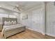 Bright bedroom boasts wood floors, a ceiling fan, and a large window providing natural light at 241 176Th Terrace E Dr, Redington Shores, FL 33708