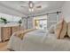 Comfortable bedroom featuring sliding barn doors, neutral tones, and a ceiling fan at 241 176Th Terrace E Dr, Redington Shores, FL 33708