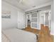 Spacious bedroom featuring neutral tones, wood floors, and a glass sliding door to the wardrobe at 241 176Th Terrace E Dr, Redington Shores, FL 33708