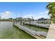 Waterfront property featuring a private boat dock with boat lift, offering direct access to the water at 241 176Th Terrace E Dr, Redington Shores, FL 33708