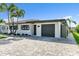 Charming single-story home with tile roof, attached garage, and paver driveway at 241 176Th Terrace E Dr, Redington Shores, FL 33708