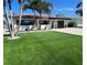 Beautiful waterfront home with manicured lawn, brick driveway, and lush tropical landscaping at 241 176Th Terrace E Dr, Redington Shores, FL 33708