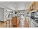 Open kitchen layout features a center island, light wood cabinets, stone counters, and water views at 241 176Th Terrace E Dr, Redington Shores, FL 33708