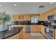 Well-lit kitchen features stone countertops, wood cabinets, and stainless steel appliances at 241 176Th Terrace E Dr, Redington Shores, FL 33708