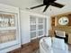 Bright office with stylish built-in shelving, desk, a comfortable white chair and sliding frosted doors at 241 176Th Terrace E Dr, Redington Shores, FL 33708