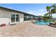 Beautiful outdoor pool and patio area with palm trees and glass sliding doors at 241 176Th Terrace E Dr, Redington Shores, FL 33708