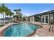 Backyard pool features brick surround, seating and palm tree landscaping at 241 176Th Terrace E Dr, Redington Shores, FL 33708
